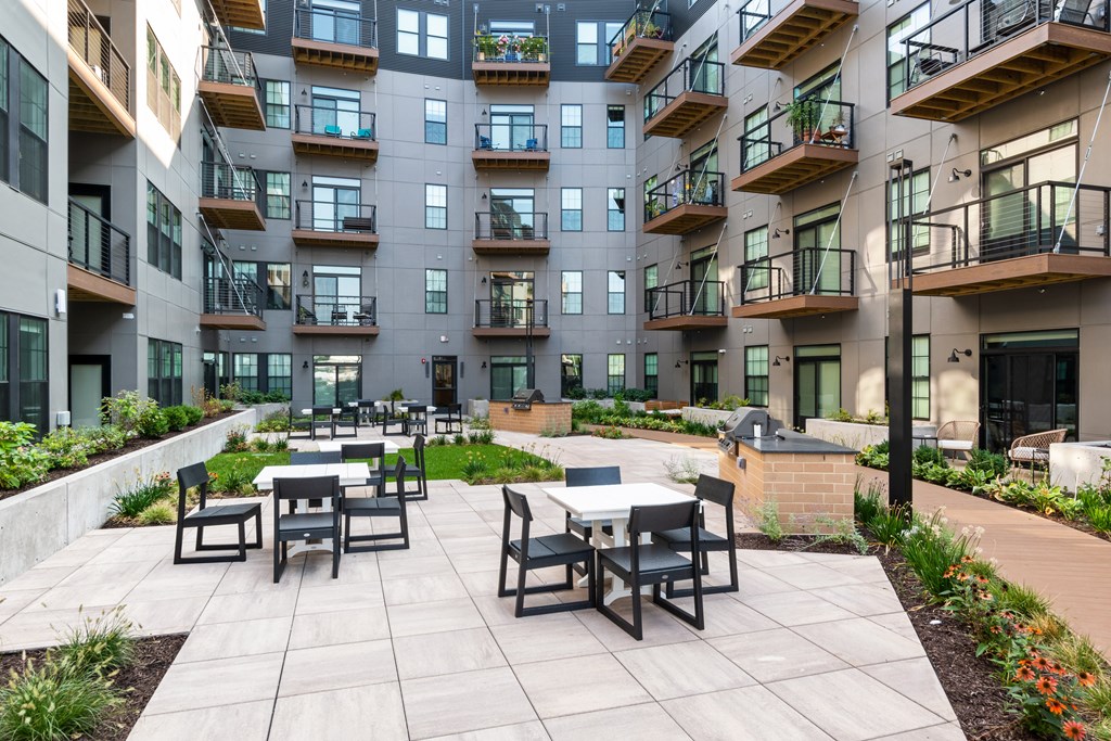 an outdoor patio with tables and chairs at the bradley braddock road station apartments
